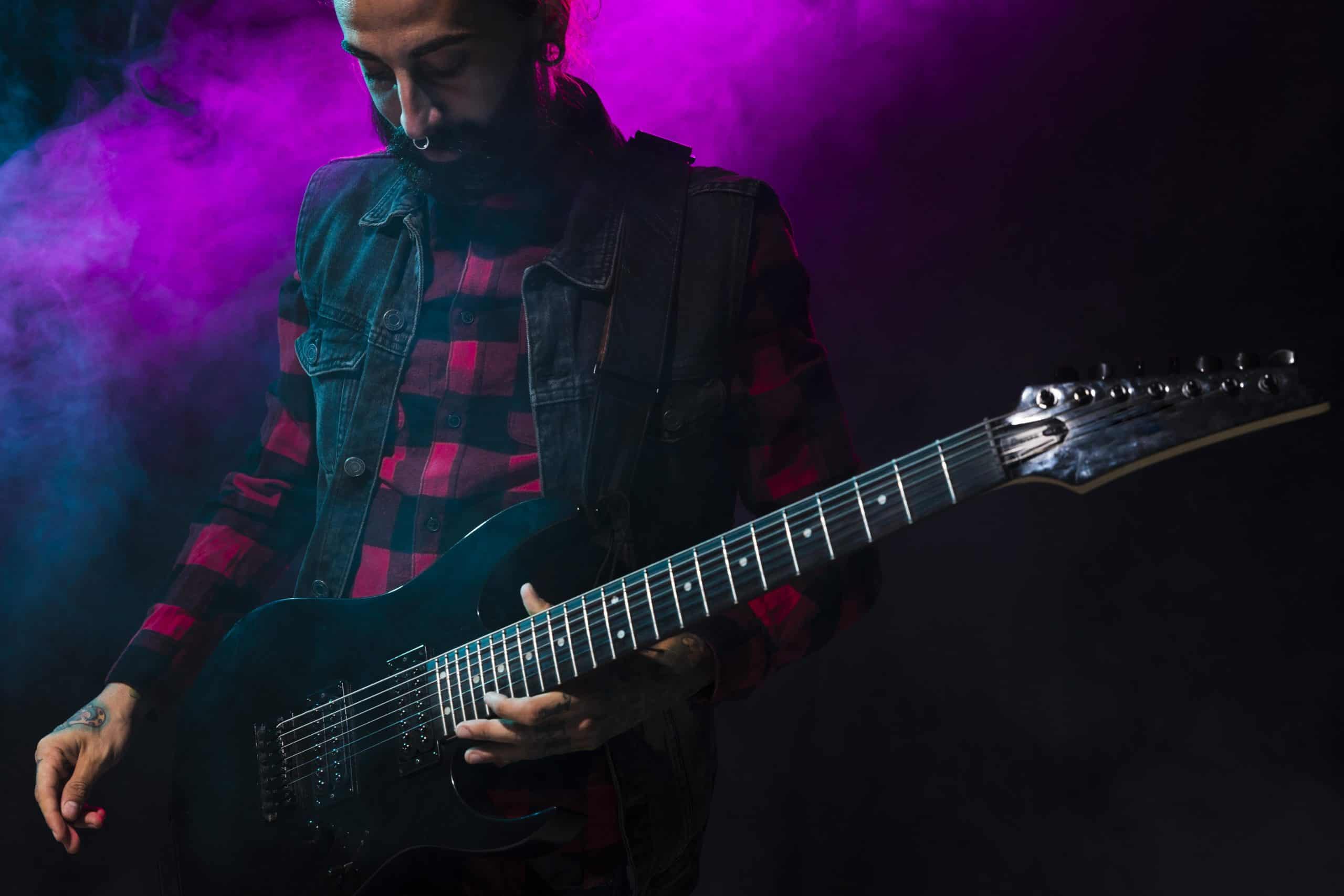 Artist Playing Guitar Violet Stage Light Smoke Scaled